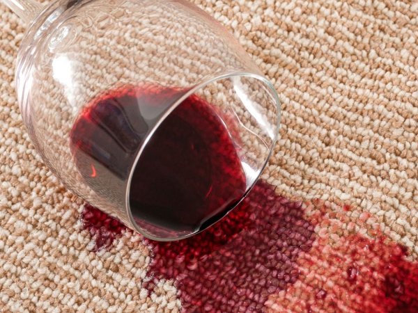 Red wine stain on a beige carpet floor